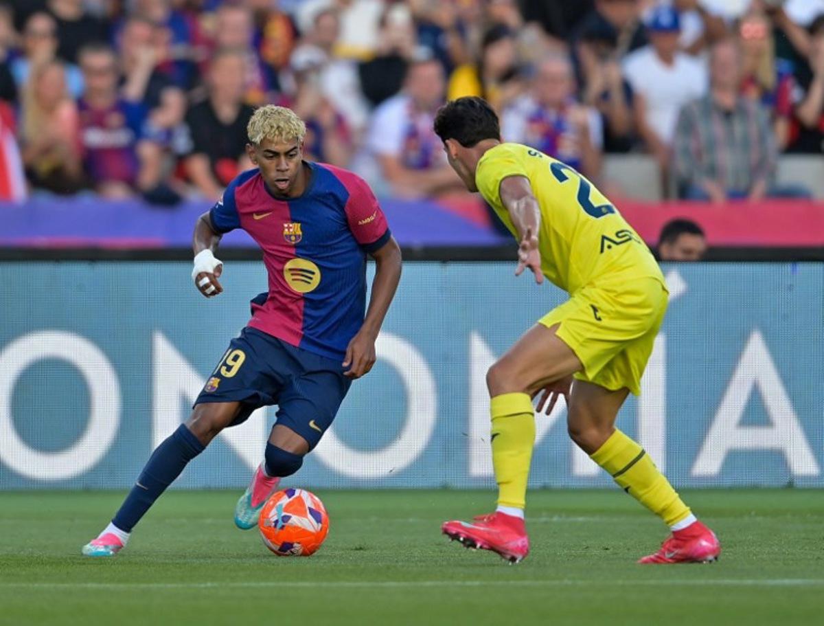 Villarreal's Spanish defender #23 Sergi Cardona (R) and Barcelona's Spanish forward #19 Lamine Yamal vie for the ball during the Spanish league football match between FC Barcelona and Villarreal CF at Estadi Olimpic Lluis Companys in Barcelona on May 18, 2025. MANAURE QUINTERO / AFP