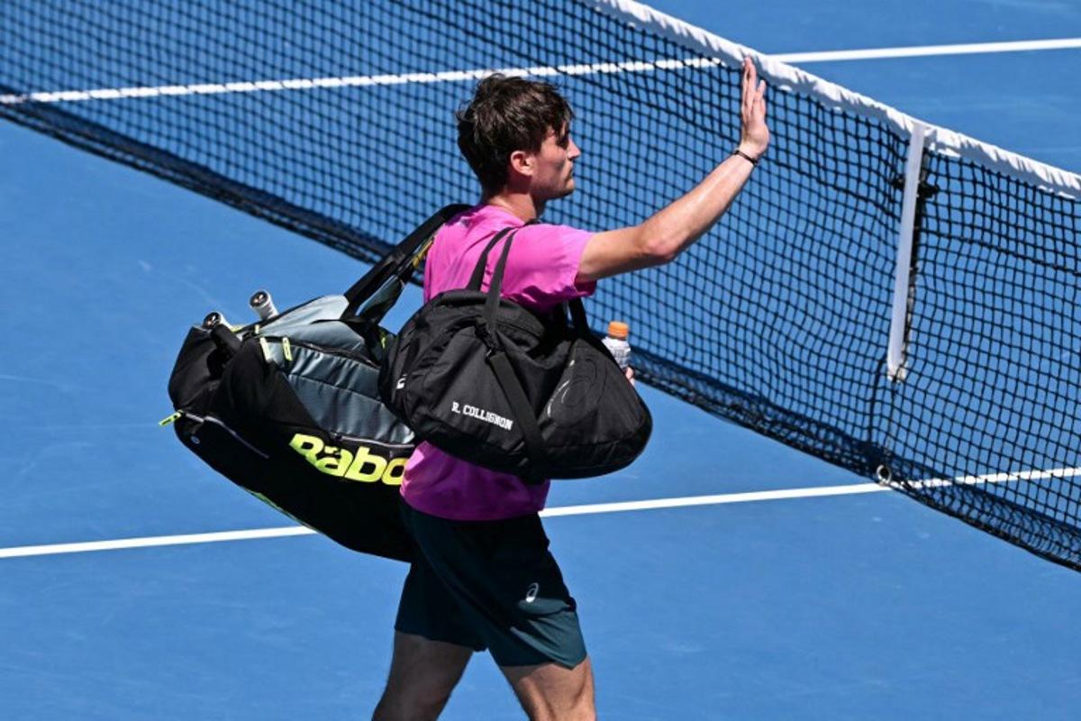 Belgium's Raphael Collignon acknowledges the crowd after he was forced to retire from the men's singles match against Italy's Lorenzo Musetti on day three of the Australian Open tennis tournament in Melbourne on January 20, 2026. WILLIAM WEST / AFP
