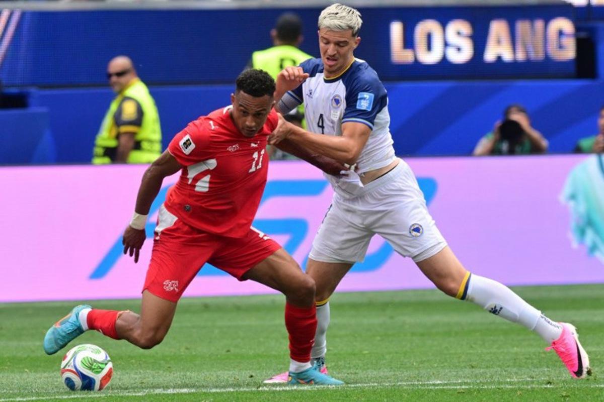 Switzerland's forward #11 Dan Ndoye and Bosnia-Herzegovina's defender #04 Tarik Muharemovic fight for the ball during the 2026 World Cup Group B football match between Switzerland and Bosnia and Herzegovina at Los Angeles Stadium in Inglewood on June 18, 2026. Frederic J. Brown / AFP