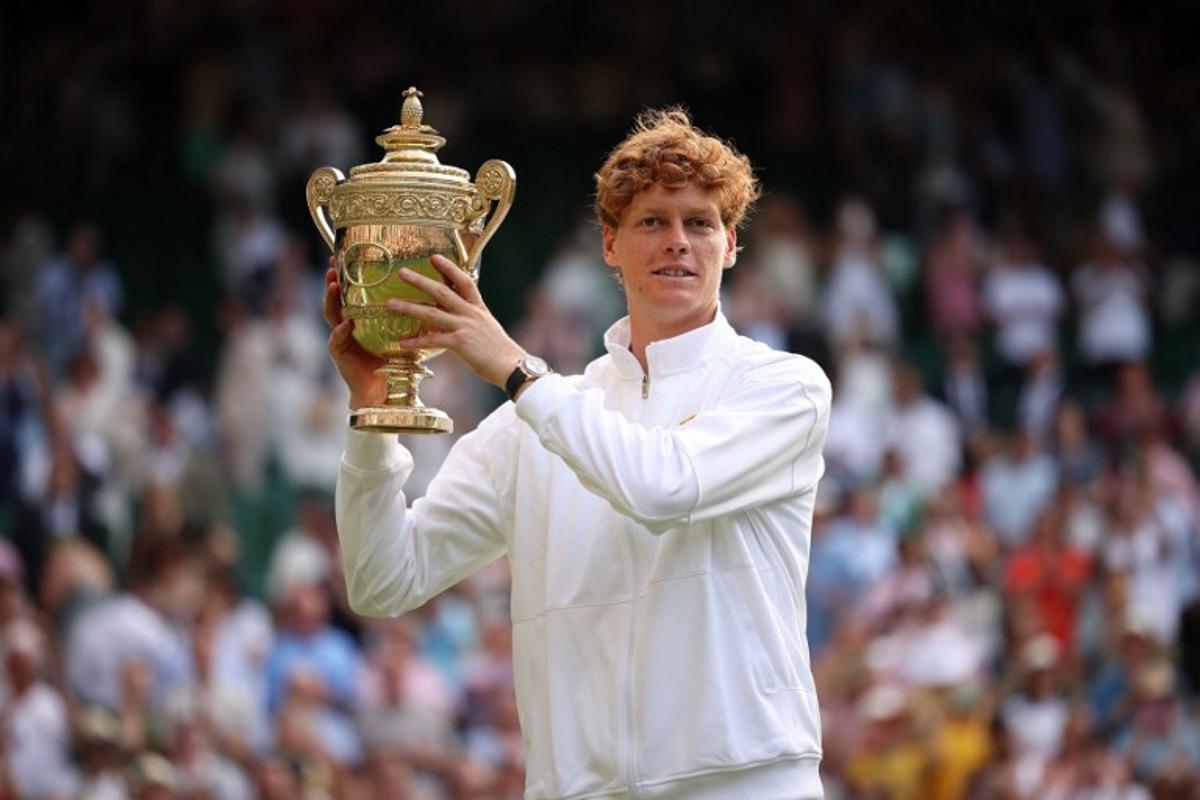 Italy's Jannik Sinner celebrates with the winner's trophy as he poses for pictures following his victory against Spain's Carlos Alcaraz at the end of their men's singles final tennis match on the fourteenth day of the 2025 Wimbledon Championships at The All England Lawn Tennis and Croquet Club in Wimbledon, southwest London, on July 13, 2025. HENRY NICHOLLS / AFP