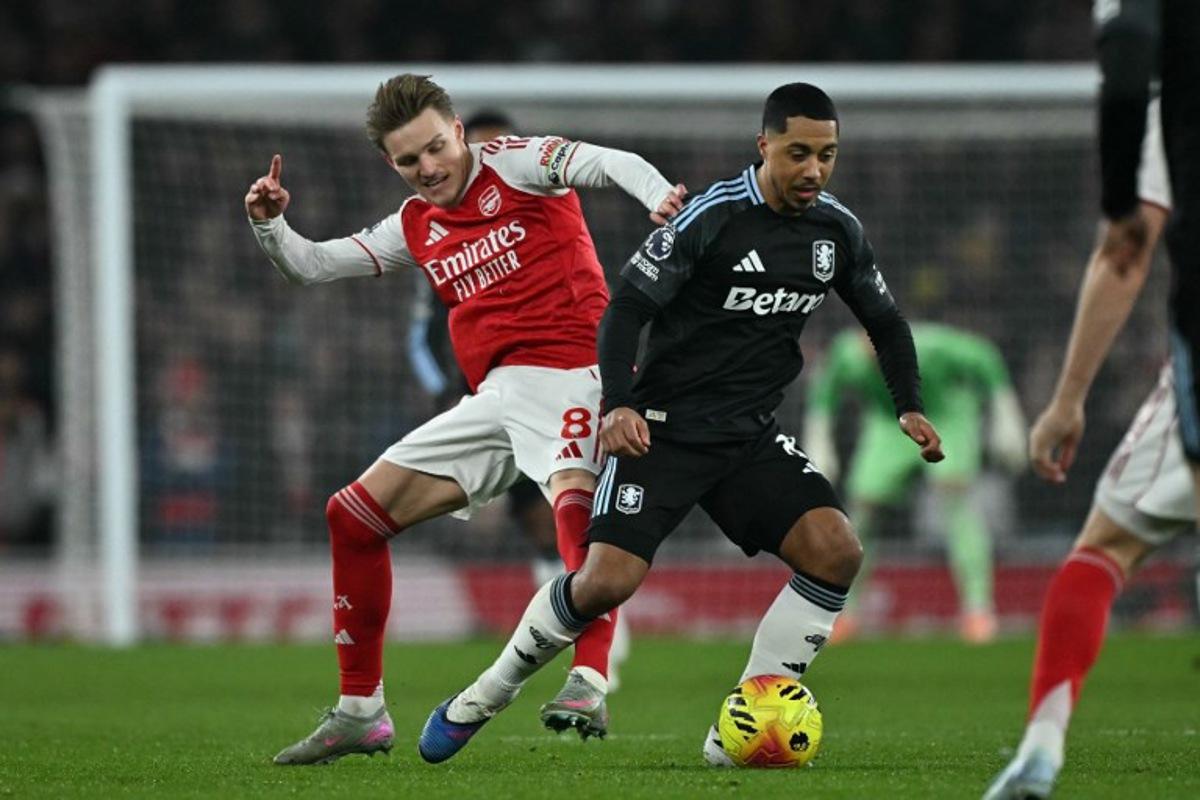 Arsenal's Norwegian midfielder #08 Martin Odegaard (L) fouls Aston Villa's Belgian midfielder #08 Youri Tielemans (R) during the English Premier League football match between Arsenal and Aston Villa at the Emirates Stadium in London on December 30, 2025. Ben STANSALL / AFP