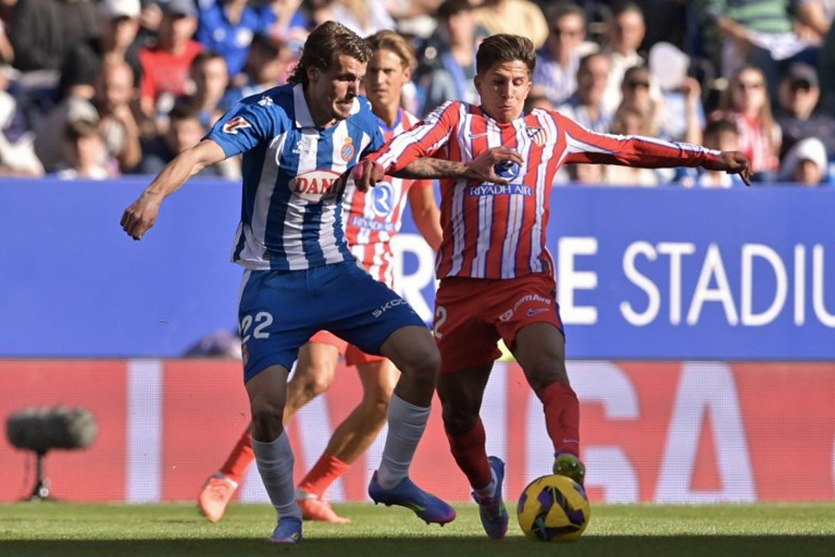 Espanyol's Spanish defender #22 Carlos Romero (L) vies for the ball with Atletico Madrid's Argentine forward #22 Giuliano Simeone during the Spanish league football match between RCD Espanyol and Club Atletico de Madrid at the RCDE Stadium in Cornella de Llobregat on March 29, 2025. MANAURE QUINTERO / AFP
