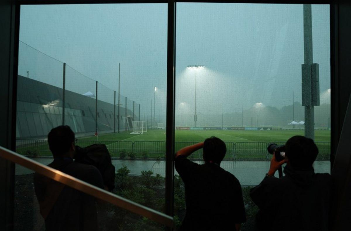 Members of the media try to record adverse weather conditions after an Argentina's training session was postponed in Morristown, New Jersey, on July 18, 2026. Spain and Argentina will meet in the 2026 World Cup football tournament final match at the New York/New Jersey Stadium in East Rutherford on July 19, 2026. PATRICIA DE MELO MOREIRA / AFP