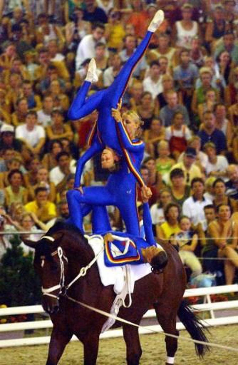 Les voltigeurs allemands, exécutent une figure le 10 août 2003 à Saumur lors des Championnats d'Europe Open Voltige. Ils remportent l'épreuve par équipe. German acrobats performs a figure, 10 August 2003 in Saumur, western France, during European equestrian Acrobatics Championship. AFP PHOTO FRANK PERRY.