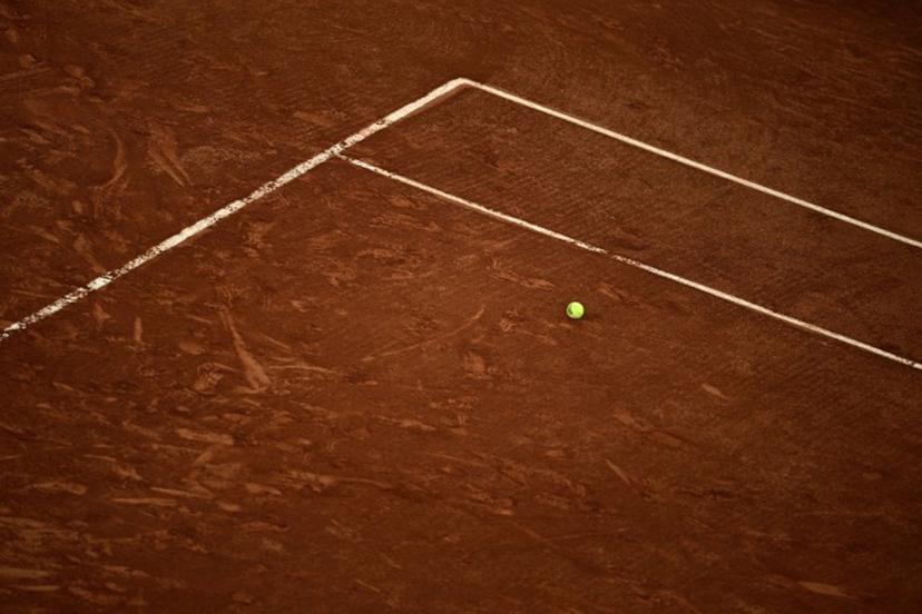 An official Roland-Garros tennis ball sits on the clay on day 1 of the French Open tennis tournament on Court Suzanne-Lenglen at the Roland-Garros Complex in Paris on May 24, 2026. JULIEN DE ROSA / AFP