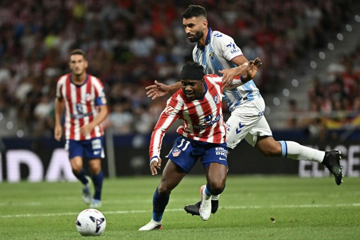 Atletico Madrid's Nigerian forward #11 Ademola Lookman vies with Malaga's Spanish defender #04 Einar Galilea (R) during the Spanish league football match between Club Atletico de Madrid and Malaga CF at the Metropolitano Stadium in Madrid on August 19, 2026. Javier SORIANO / AFP