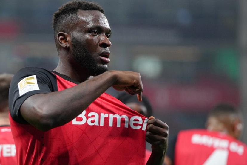 Bayer Leverkusen's Nigerian forward #22 Victor Boniface points to the club badge as he celebrates scoring the 2-1 goal with his teammates during the German first division Bundesliga football match between Bayer 04 Leverkusen and VfL Bochum in Leverkusen, western Germany on March 28, 2025. Pau BARRENA / AFP