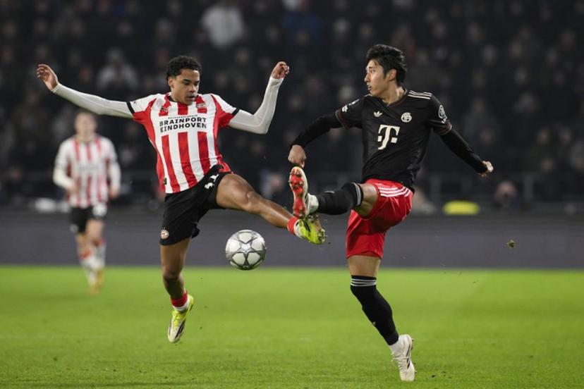 PSV Eindhoven's Belgian midfielder #31 Noah Fernandez (L) fights for the ball with Bayern Munich's Japanese defender #21 Hiroki Ito during the UEFA Champions League league phase day 8 football match between PSV Eindhoven and Bayern Munich at Philips Stadion in Eindhoven on January 28, 2026. JOHN THYS / AFP
