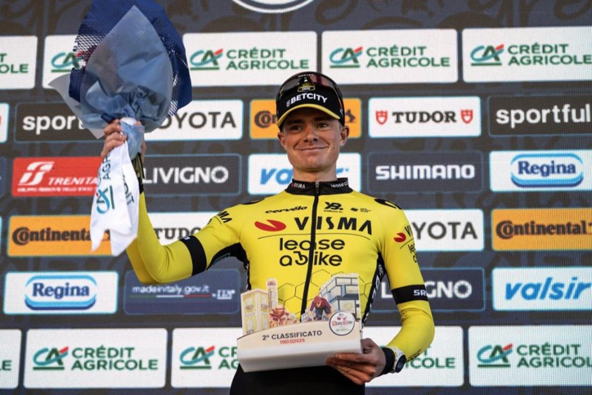 Second-placed Team Visma Lease a Bike, Britain's rider Ben Tulett (R) celebrates on the podium of the 106th edition of the one-day classic cycling race Milan - Torino between Rho, west of Milan, and Superga, east of Torino, on March 19, 2025. MARCO BERTORELLO / AFP
