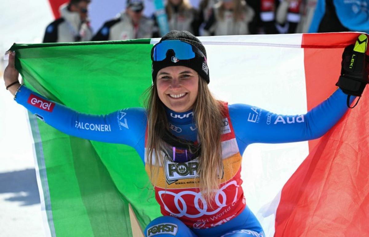 Winner Italy's Laura Pirovano poses with the Italian flag after the Women's Downhill race of the FIS Ski World Cup at the La Volata slope in the Passo San Pellegrino ski area, Val di Fassa, Italy on March 7, 2026. Andreas SOLARO / AFP