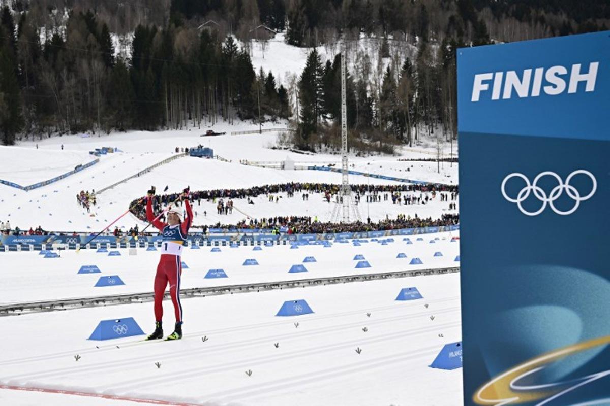Norway's Johannes Hoesflot Klaebo celebrates as he crosses the finish line to win gold in the men's cross country 50km mass start final event of the Milano Cortina 2026 Winter Olympic Games at Tesero Cross-Country Skiing Stadium in Lago di Tesero (Val di Fiemme) on February 21, 2026. Tobias SCHWARZ / AFP