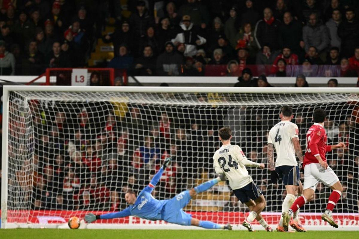 Wrexham's New Zealand defender #13 Liberato Cacace (R) scores the opening goal past Nottingham Forest's Belgian goalkeeper #26 Matz Sels during the English FA Cup third round football match between Wrexham and Nottingham Forest at the Racecourse Ground Stadium in Wrexham, north Wales, on January 9, 2026. Oli SCARFF / AFP