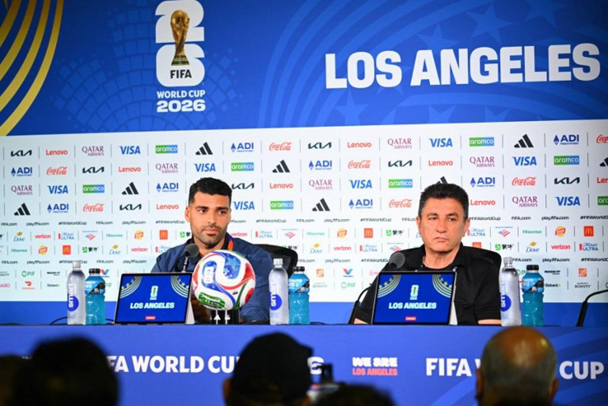 Iran's head coach Amir Ghalenoei (R) gives a press conference next to Iran's forward #09 Mehdi Taremi at Los Angeles Stadium in Inglewood on June 14, 2026, on the eve of the 2026 World Cup football match between Iran and New Zealand. Patrick T. FALLON / AFP