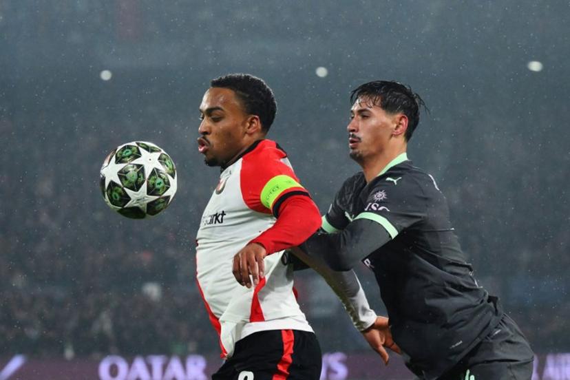 Feyenoord's Dutch midfielder #08 Quinten Timber (L) fights for the ball with AC Milan's Dutch midfielder #14 Tijani Reijnders during the UEFA Champions League knockout phase play-off 1st leg football match between Feyenoord Rotterdam and AC Milan at the Stadion Feijenoord "De Kuip" in Rotterdam, on February 12, 2025. JOHN THYS / AFP