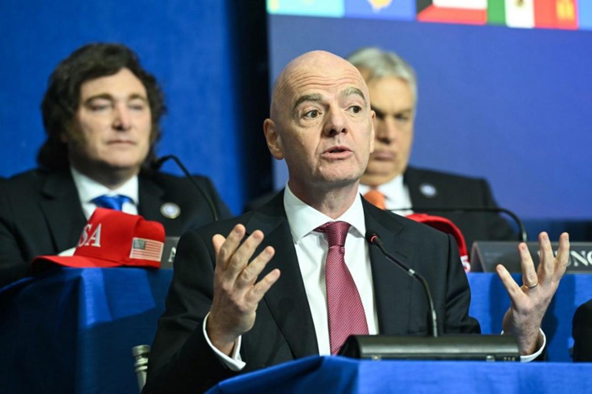 (L/R) Argentina's President Javier Milei looks on as FIFA President Gianni Infantino speaks during the inaugural meeting of the "Board of Peace" hosted by US President Donald Trump at the US Institute of Peace in Washington, DC, on February 19, 2026. President Trump on Thursday gathers allies to inaugurate the "Board of Peace," his new institution focused on progress on Gaza but whose ambitions reach much further. Around two dozen world leaders or other senior officials have come to Washington for the meeting -- including several of Trump's authoritarian-leaning friends and virtually none of the European democrats that traditionally sign on to US initiatives. SAUL LOEB / AFP