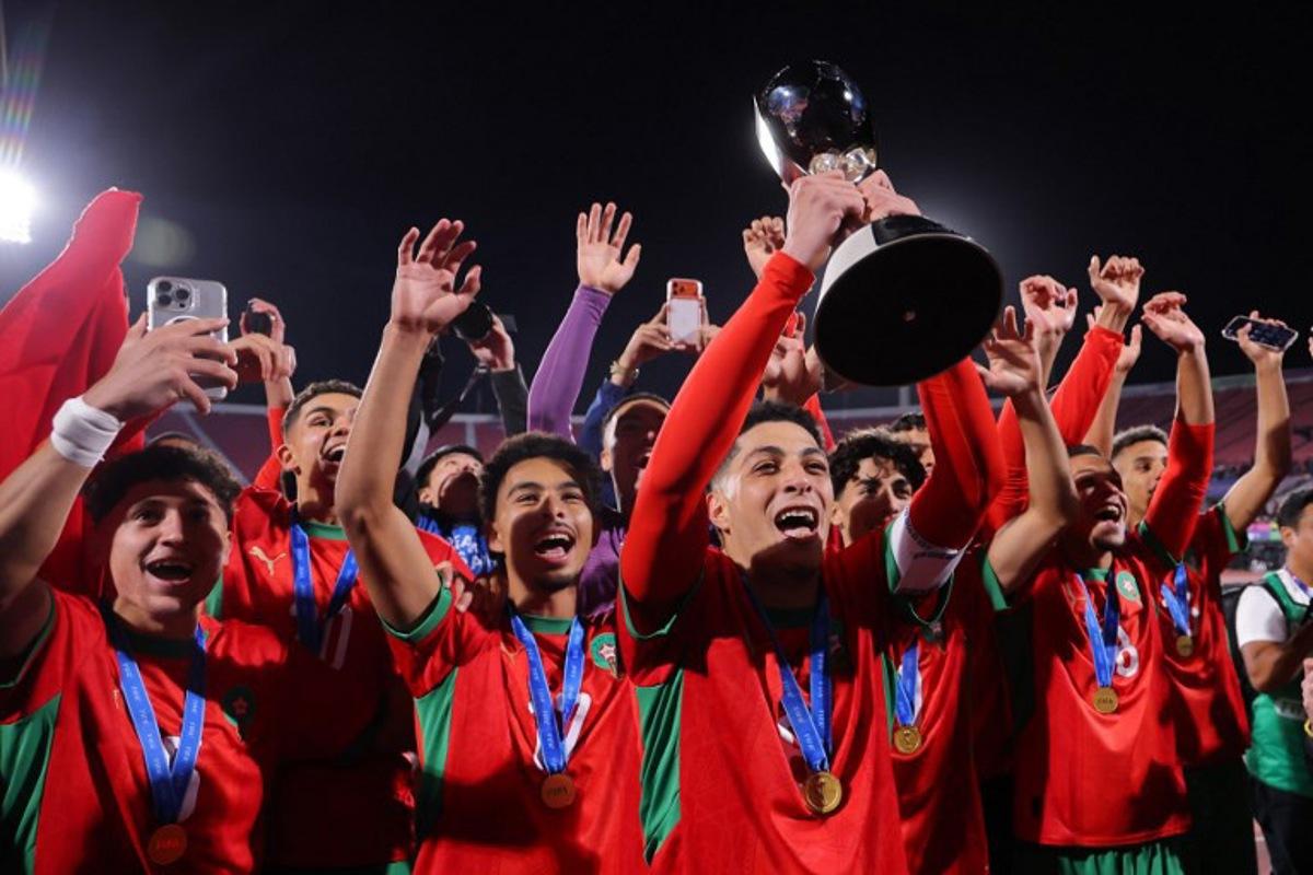 Morocco's midfielder #08 Houssam Essadak holds the trophy while celebrating with his teammates after winning the 2025 FIFA U-20 World Cup final football match between Argentina and Morocco at the National Stadium in Santiago on October 19, 2025. Javier TORRES / AFP