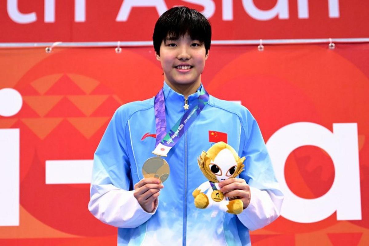 Gold medallist China's Yu Zidi celebrates on the podium during the victory ceremony of the women's 200m butterfly swimming event during the 2026 Asian Games at the Tokyo Aquatics Centre in Tokyo on September 20, 2026. Yuichi YAMAZAKI / AFP