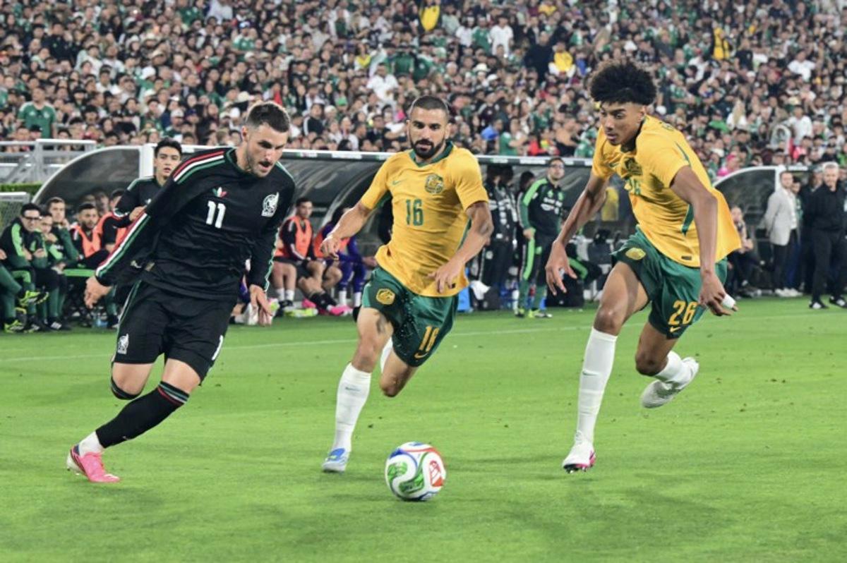 Mexico's forward #11 Santiago Gimenez vies for the ball with Australia's defender #16 Aziz Behich and Australia's defender #26 Lucas Herrington during a friendly football match between Mexico and Australia at The Rose Bowl in Pasadena, California, on May 30, 2026. Frederic J. Brown / AFP