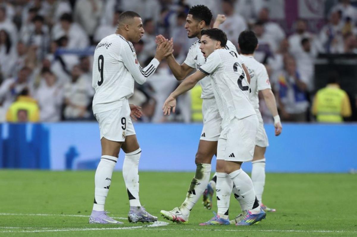 Real Madrid's English midfielder #05 Jude Bellingham (C) celebrates scoring their second goal with Real Madrid's French forward #09 Kylian Mbappe during the Spanish league football match between Real Madrid CF and Club Deportivo Leganes SAD at the Santiago Bernabeu stadium in Madrid on March 29, 2025. Thomas COEX / AFP