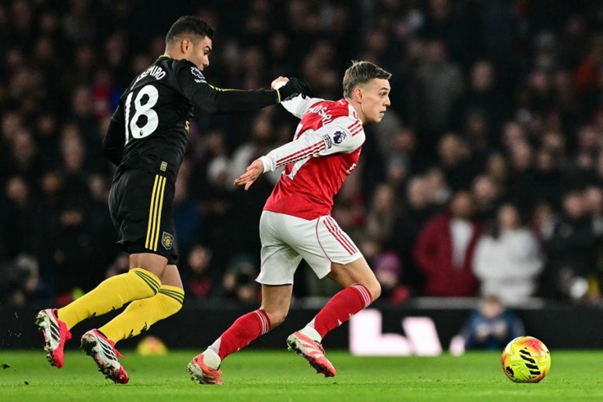 Manchester United's Brazilian midfielder #18 Casemiro (L) tackles Arsenal's Belgian midfielder #19 Leandro Trossard (R) for a free kick during the English Premier League football match between Arsenal and Manchester United at the Emirates Stadium in London on January 25, 2026. Ben STANSALL / AFP
