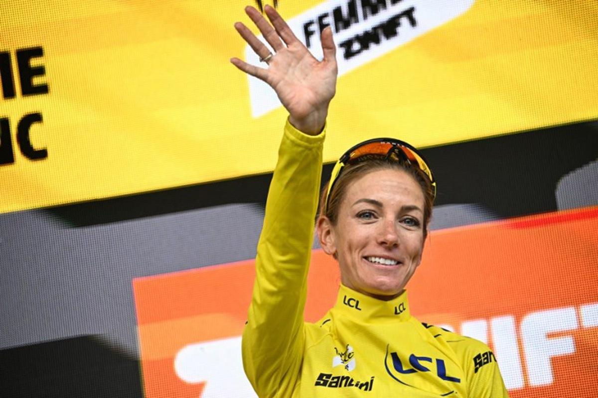 Team Visma | Lease a Bike's French rider Pauline Ferrand-Prevot celebrates with the overall leader's yellow jersey on the podium for the fourth edition of the Women's Tour de France cycling race at the end of the 9th and final stage (out of 9), 124.1 km from Praz-sur-Arly to Chatel, in Chatel eastern France, on August 3, 2025. JULIEN DE ROSA / AFP
