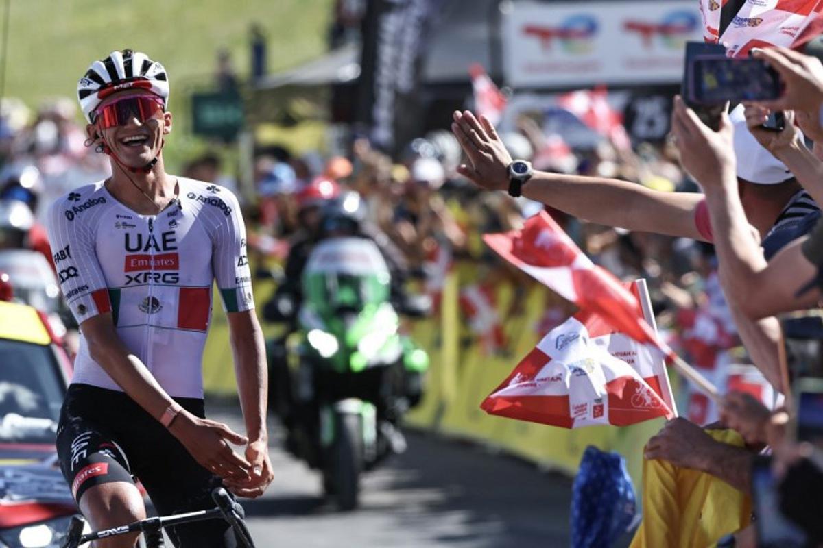 UAE Team Emirates XRG's Mexican rider Isaac Del Toro Romero celebrates as he cycles to the finish line to win the 8th and final stage of the Tour Auvergne-Rhone-Alpes cycling race (formerly known as the Criterium du Dauphine), 120,1km between Beaufort and Plateau de Solaison, in the French Alps on June 14, 2026. Anne-Christine POUJOULAT / AFP
