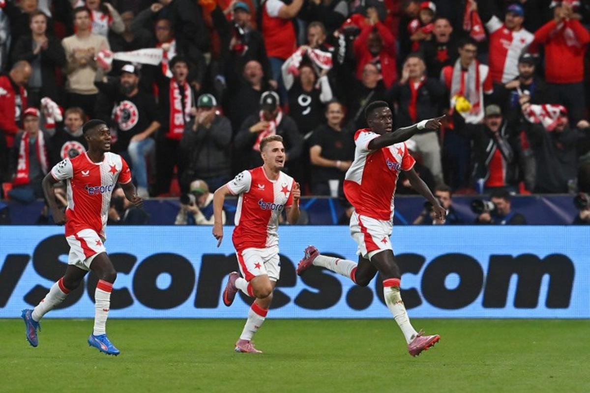 Slavia Prague's Senegalese defender #12 Youssoupha Mbodji (R) celebrates scoring his team's first goal with team mates during the UEFA Champions League football match between SK Slavia Prague and FK Bodoe/Glimt in Prague on September 17, 2025. Michal Cizek / AFP