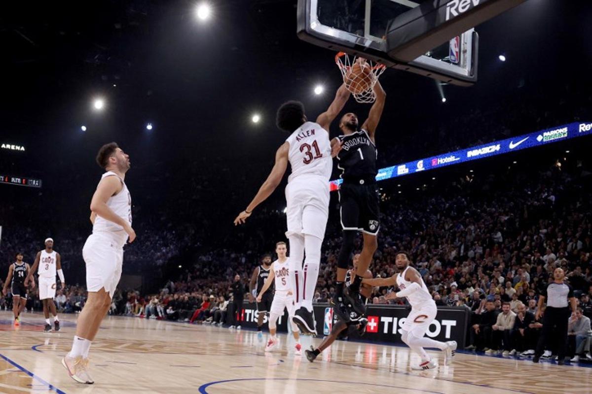 Brooklyn Nets' US Point Guard Mikal Bridges (R) scores in front of Cleveland Cavaliers' US Center Jarrett Allen (L) during the NBA regular season basketball match between the Cleveland Cavaliers and the Brooklyn Nets at the Accor Arena in Paris on January 11, 2024. EMMANUEL DUNAND / AFP