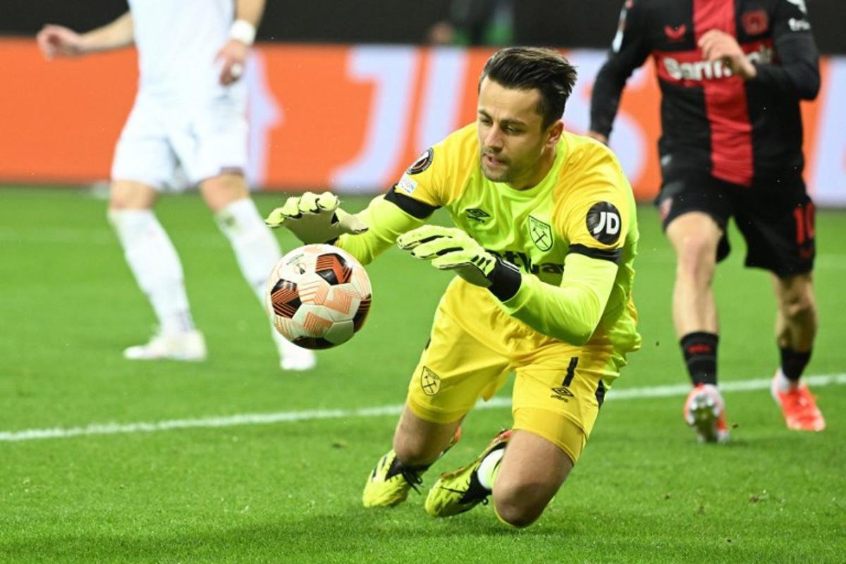 West Ham United's Polish goalkeeper #01 Lukasz Fabianski saves the ball during the UEFA Europa League quarter-final first leg football match between Bayer 04 Leverkusen and West Ham United FC in Leverkusen, western Germany on April 11, 2024. INA FASSBENDER / AFP