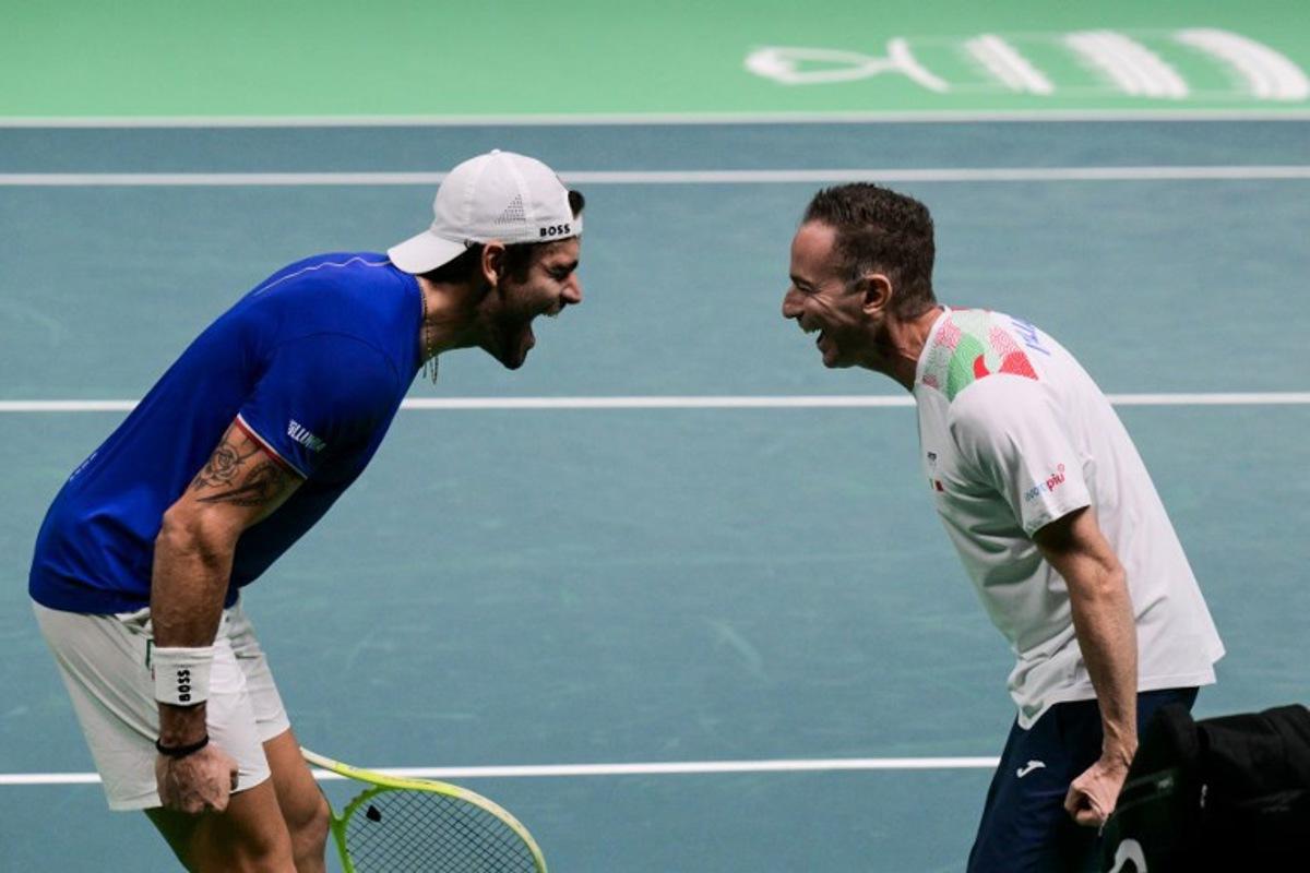 Italy's Matteo Berrettini (L) celebrates with Italy's coach Filippo Volandri after winning against Austria's Jurij Rodionov during their Davis Cup men's singles quarter finals tennis match, at the Super Tennis Arena, in Bologna, northen Italy, on November 19, 2025. Tiziana FABI / AFP