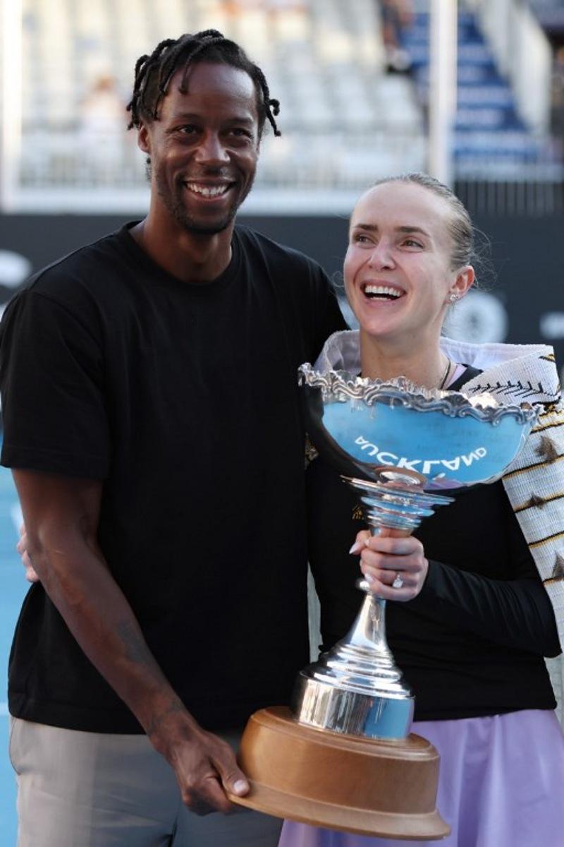 Ukraine's Elina Svitolina celebrates with the trophy and husband Gael Monfils after her win against China's Wang Xinyu during the women's singles final at the WTA Auckland Classic tennis tournament in Auckland on January 11, 2026. Michael Bradley / AFP