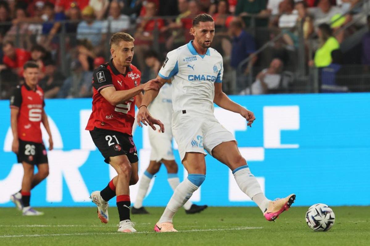 Marseille's French midfielder #25 Adrien Rabiot (R) makes a pass challenged by Rennes' French midfielder #21 Valentin Rongier during the French L1 football match between Stade Rennais FC and Olympique de Marseille (OM) at Roazhon Park stadium in Rennes, western France, on August 15, 2025. FRED TANNEAU / AFP