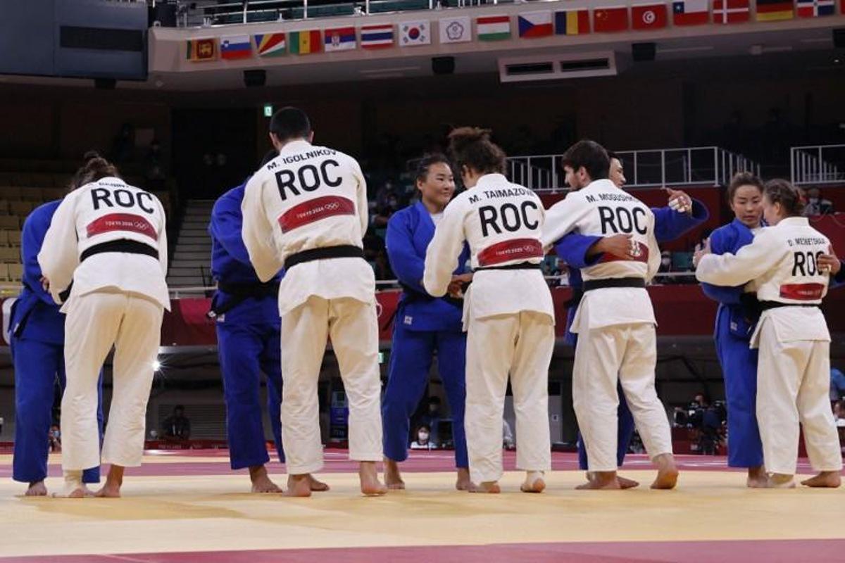 Team Russia (white) comforts team Mongolia at the end of their judo mixed team's quarterfinal match during the Tokyo 2020 Olympic Games at the Nippon Budokan in Tokyo on July 31, 2021. Jack GUEZ / AFP