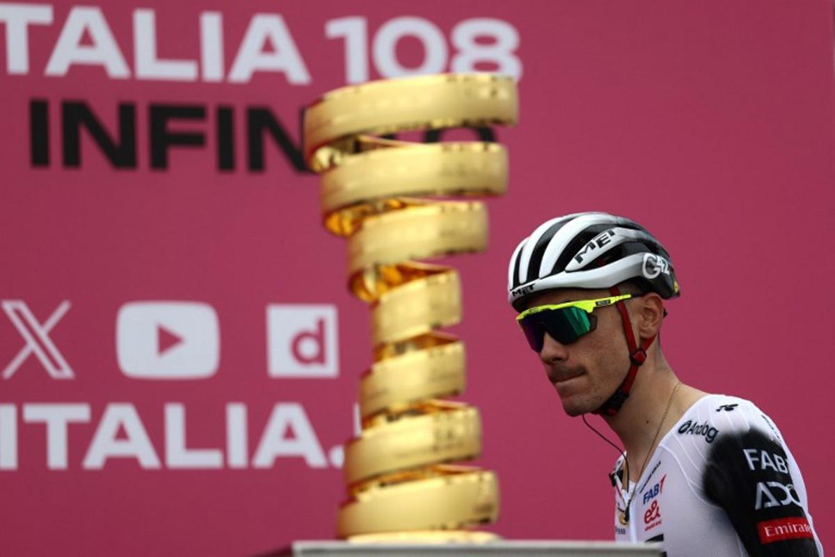 UAE Team Emirates XRG's Spanish rider Juan Ayuso walks past the Giro d'Italia trophy ("trofeo senza fine") prior to the first stage of the 108th Giro d'Italia cycling race, 160km from Durres to Tirana in Albania, on May 9, 2025. Luca Bettini / AFP