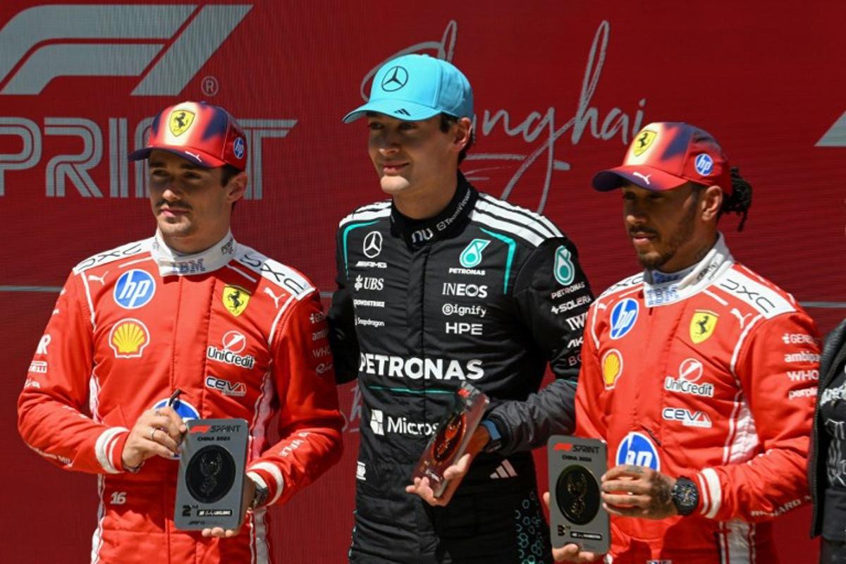 Mercedes' British driver George Russell (C) celebrates winning next to second-placed Ferrari's Monegasque driver Charles Leclerc (L) and third-placed Ferrari's British driver Lewis Hamilton (R) after the sprint race ahead of the Formula One Chinese Grand Prix at the Shanghai International Circuit in Shanghai on March 14, 2026. JADE GAO / AFP