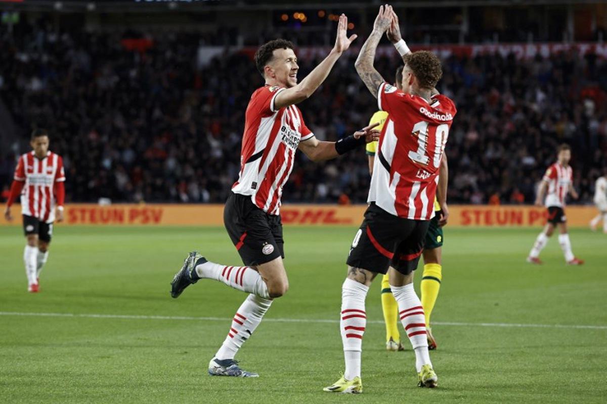 PSV Eindhoven's Croatian #5 defender Ivan Perisic (L) celebrates with his teammate PSV Eindhoven's Dutch forward #10 Noa Lang after scoring his team's second goal during the Dutch Eredivisie football match between PSV Eindhoven and SC Heerenveen at Philips Stadion in Eindhoven on March 8, 2025. MAURICE VAN STEEN / ANP / AFP