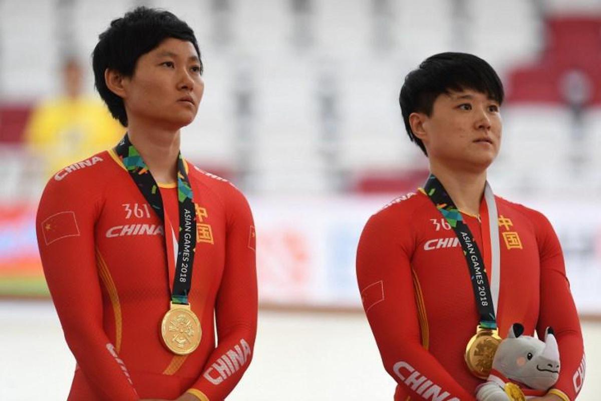 China's gold medallists Zhong Tianshi (L) and Lin Junhong (R) pose on the podium during the awards ceremony for the women's team sprint event at the cycling track competition at the 2018 Asian Games in Jakarta on August 27, 2018. Arief Bagus / AFP