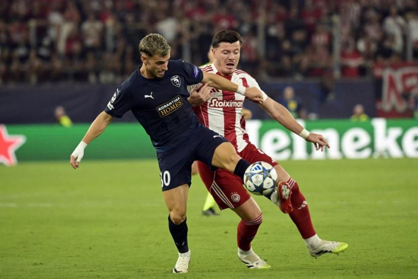 Pafos FC's Romanian midfielder #30 Vlad Dragomir (L) and Olympiakos' French defender #04 Giulian Biancone fight for the ball during the UEFA Champions League football league stage match between Olympiakos and Pafos at the Karaiskakis stadium in Piraeus on September 17, 2025. Angelos Tzortzinis / AFP