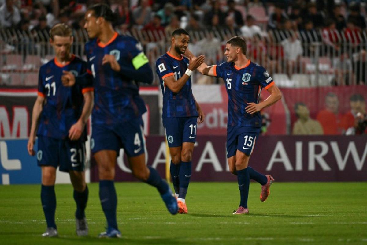 Netherlands' forward #11 Cody Gakpo (C) celebrates with Netherlands' defender #15 Micky van de Ven (R) after succesfully converting a penalty to score the Netherlands' first goal during the FIFA World Cup 2026 Group G qualification football between Malta and Netherlands at the National Stadium in Ta' Qali, on October 9, 2025. Alberto PIZZOLI / AFP