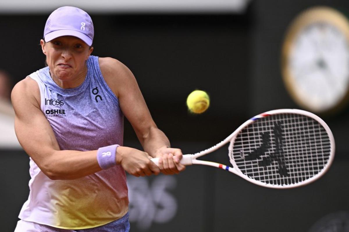 Poland's Iga Swiatek plays a backhand return to Britain's Emma Raducanu during their women's singles match on day 4 of the French Open tennis tournament on Court Philippe-Chatrier at the Roland-Garros Complex in Paris on May 28, 2025. JULIEN DE ROSA / AFP