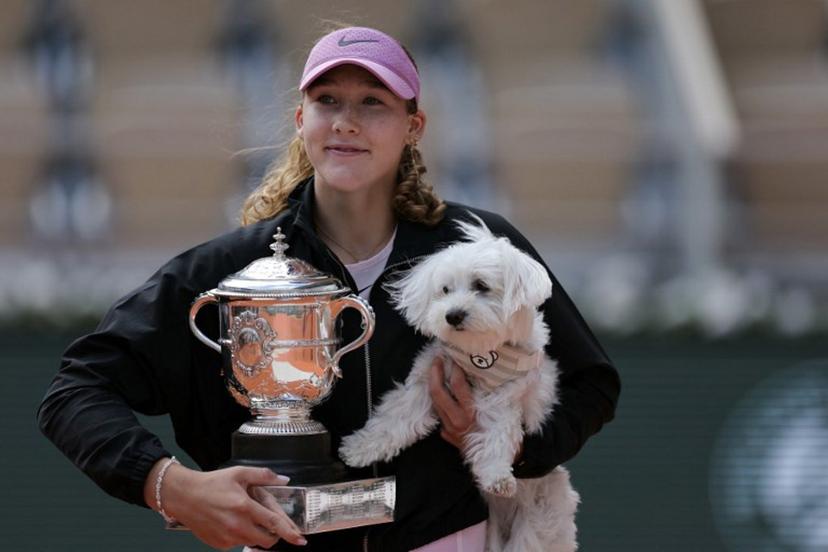 Russia's Mirra Andreeva poses with the Coupe Suzanne Lenglen (Suzanne Lenglen Trophy) and her dog after winning the French Open tennis tournament women's singles final match against Poland's Maja Chwalinska on day 14 of the French Open tennis tournament on Court Philippe-Chatrier at the Roland-Garros Complex in Paris on June 6, 2026. Thomas SAMSON / AFP