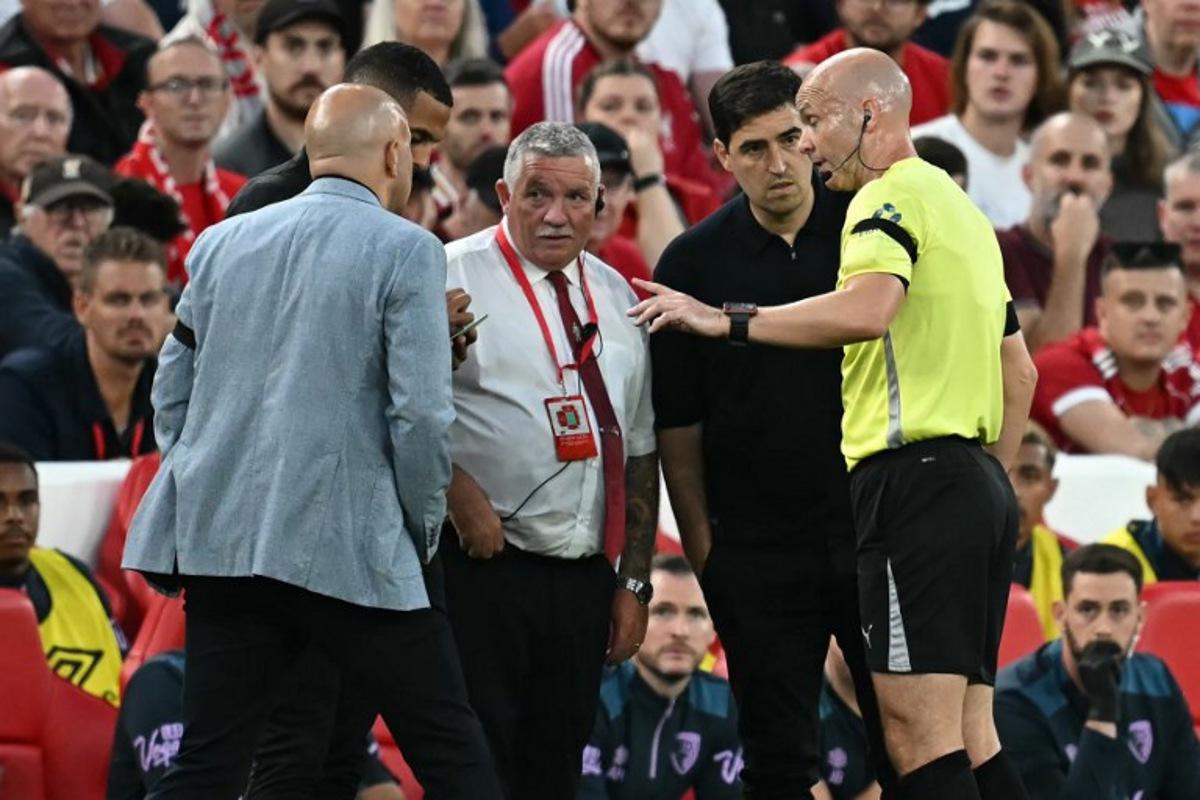 English referee Anthony Taylor (R) speaks with both coaches and the stadium safety officer after a member of the crowd shouted abuse at Bournemouth's Ghanaian striker #24 Antoine Semenyo during the English Premier League football match between Liverpool and Bournemouth at Anfield in Liverpool, north west England on August 15, 2025. Paul ELLIS / AFP
