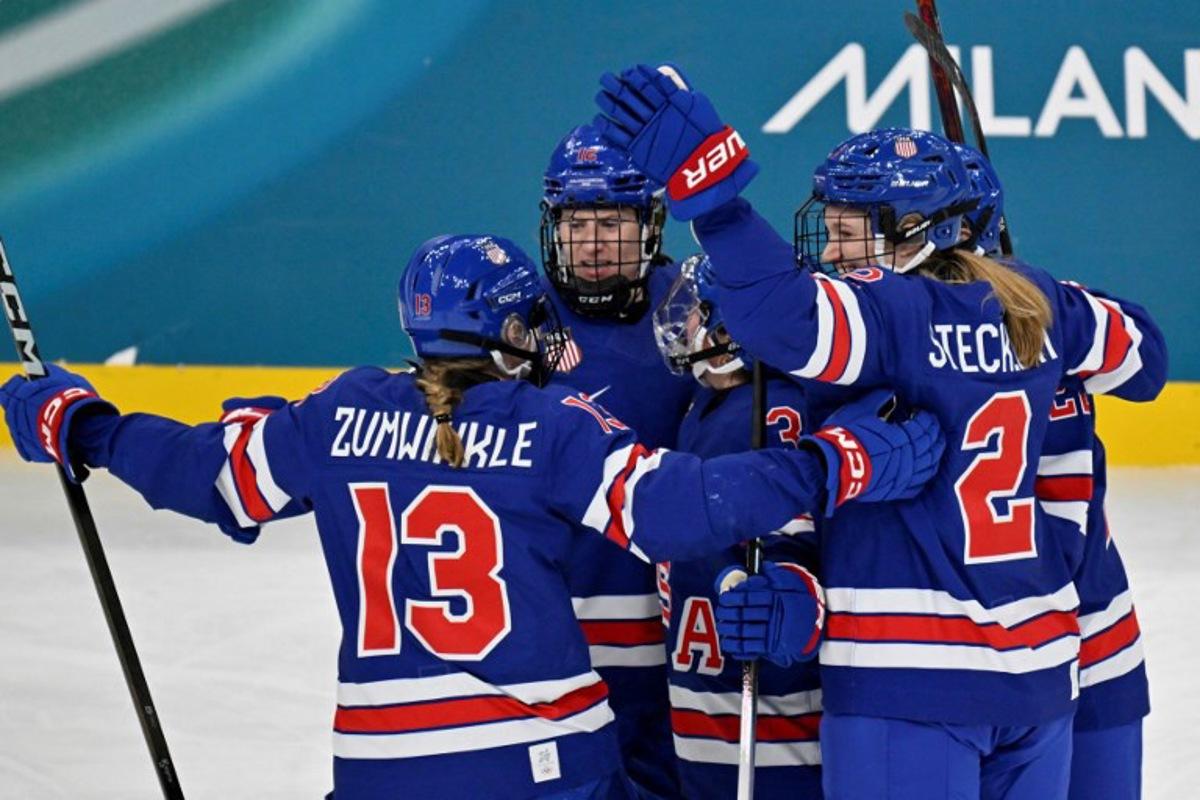 USA's defender #03 Cayla Barnes (unseen) celebrates with teammates after scoring her team's first goal during the women's play-off semi-final ice hockey match between USA and Sweden at the Milano Santagiulia Ice Hockey Arena during the Milano Cortina 2026 Winter Olympic Games in Milan, on February 16, 2026. Alexander NEMENOV / AFP